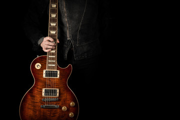 Obraz premium Trzyma czerwoną gitarę elektryczną.