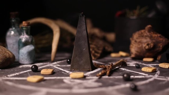 Black magic candles burn and go out from a gust of wind. Smoke on the background of the magical attributes of black art. Halloween concept.