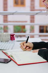 woman writing in her diary by the computer