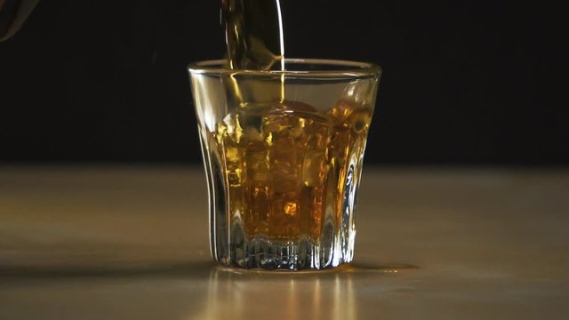 Alcohol. Cognac is poured into a glass.