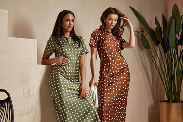 Two fashion model brunette hair wear green  brown dots silk dress shoes accessory clothes date...
