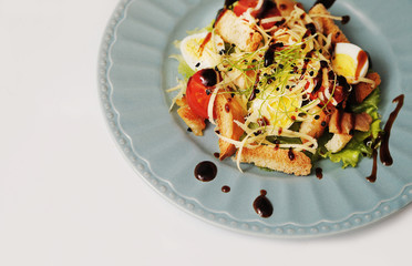 Delicious Caesar salad in blue plate. Delicious food.