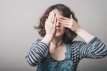 girl covers her face with her hands