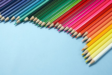 Assortment of coloured pencils on blue background
