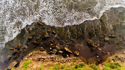 People watching the sunset in the sea, sitting on a rock by the sea. Top view.