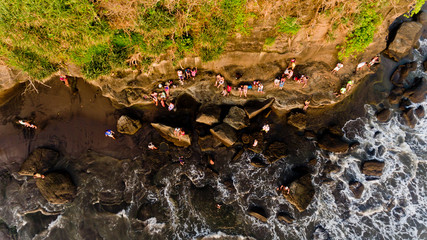 People watching the sunset in the sea, sitting on a rock by the sea. Top view.