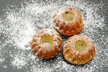 round cake with powdered sugar on black plate