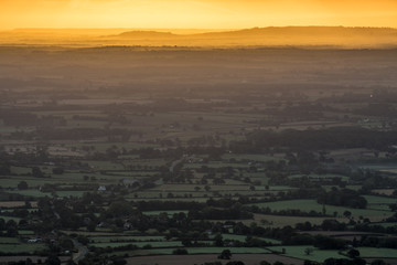 Sun rising on an early, cold winter morning over the West Midlands countryside.  Light breaking through the early morning mist/fog in the distance