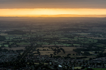 Sun rising on an early, cold winter morning over the West Midlands countryside.  Light breaking through the early morning mist/fog in the distance