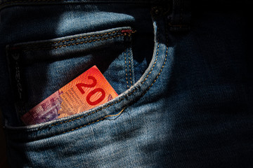 Twenty Swiss francs paper note in jeans pocket.