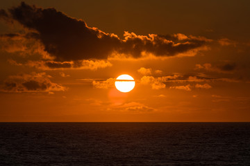 Sun setting above the horizon on a late summers evening.  Taken out to sea from Croyde Bay, UK