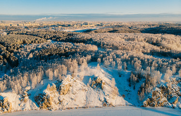Aerial view of the winter snow covered forest and frozen river from above captured with a drone
