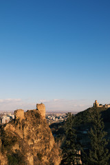 Obraz premium Sunlit high wall at part of fortress and blue sky at sunny evening