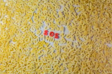 Morse code S.O.S. word with alphabet letters soup pasta. Aid concept.