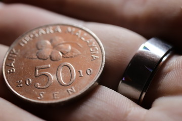 50 sen coin in hand with steel ring © Aleksander