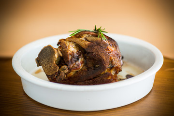 baked pork shank with spices in ceramic form