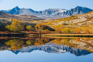 Obraz premium Mountain reflection on calm lake at autumn, Norway.