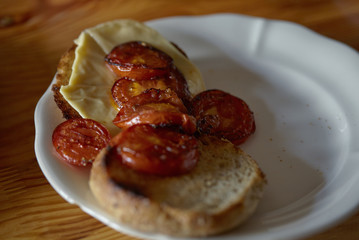 sandwich on toasted crust of bread with cheese and toasted tomatoes.