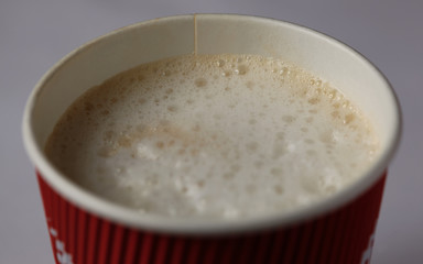 Take-out coffee in opened thermo cup against white.