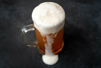fresh beer in a beer glass on a stone background
