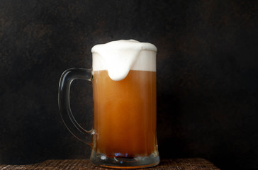 fresh beer in a beer glass on a stone background
