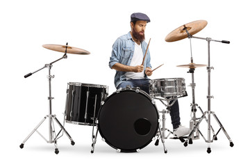 Casual bearded guy mucician playing a drum set