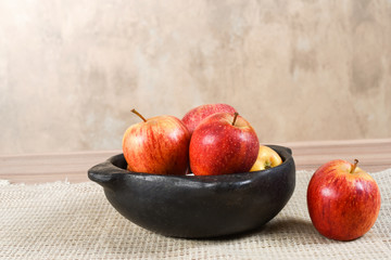 natural and healthy apples tropical fruit cut into slices with bowl of apple vinegar on the table on blurred texture background.