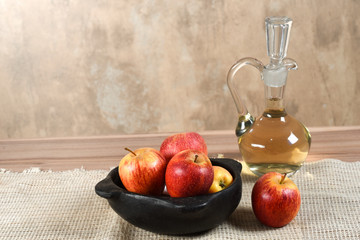 natural and healthy apples tropical fruit cut into slices with bowl of apple vinegar on the table on blurred texture background.