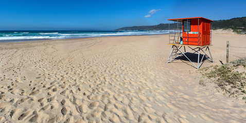 Lifesaver hut with large empty beach
