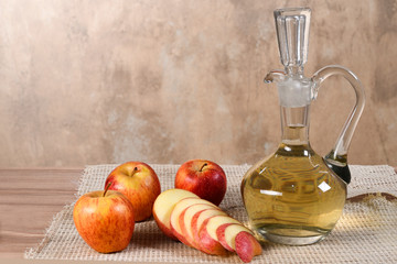 natural and healthy apples tropical fruit cut into slices with bowl of apple vinegar on the table on blurred texture background.