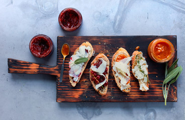 toast and snacks with cheese herbs and jam on a wooden Board