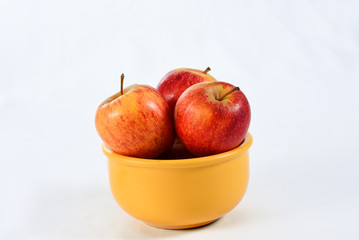 natural and healthy apples tropical fruit inside a yellow pot isolated on bench background.
