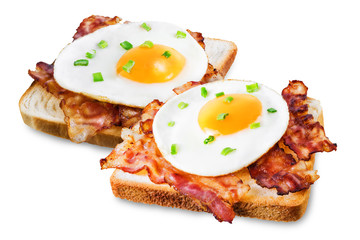 Fried egg fried bacon sandwich on a white isolated background