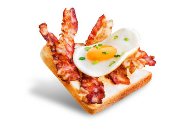 Fried egg fried bacon sandwich on a white isolated background