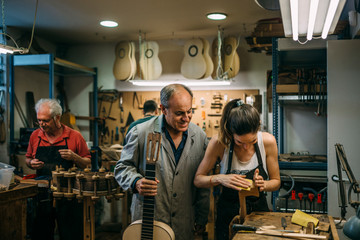 Luthiers working in traditional guitar making business