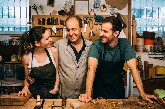Happy family posing in their traditional guitar making workshop - Powered by Adobe