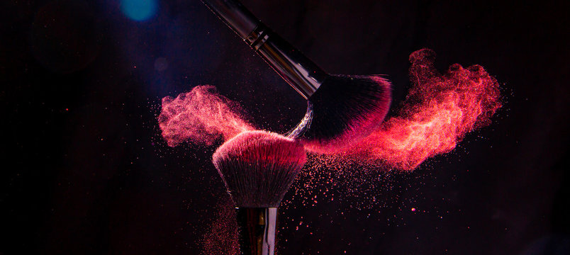 Colorful explosion on makeup brushes on a black background