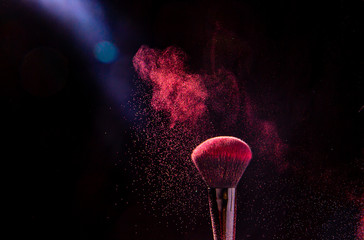Colorful explosion on makeup brushes on a black background