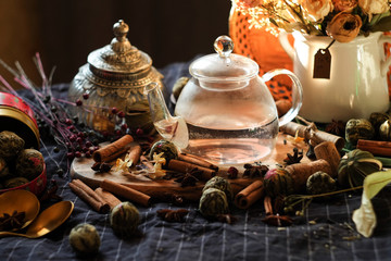 Fototapeta na wymiar transparent glass teapot with tea, anise, cinnamon, cans and buds and flowers