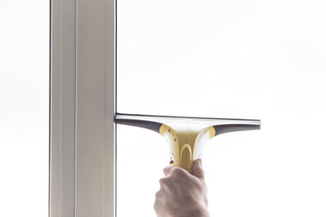 Cleaning windows with electric vacuum cleaner. Spring house cleaning- image.Window washing with a vacuum cleaner.hand with portable professional vacuum cleaner