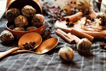 two golden spoons on a black napkin and tea in a can and spices
