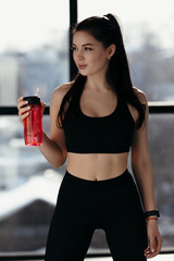 Fitness instructor conducts exercise at home. Drinking water after a hard workout and takes a breath.