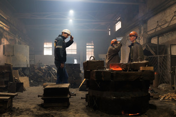 Factory workers near mold with hot metal