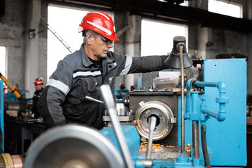 Serious male using lathe in workshop