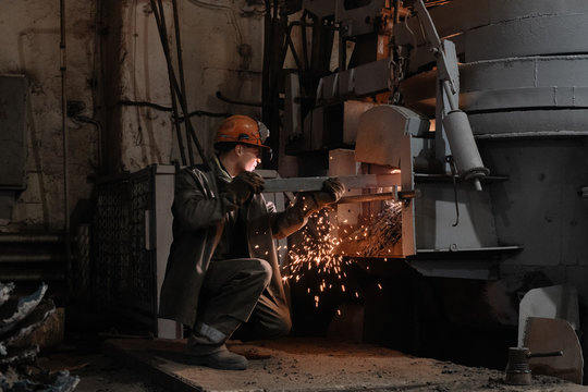 Factory employee working with hot furnace