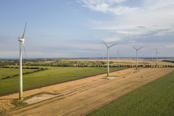 Aerial view of wind turbine generators in field producing clean ecological electricity.