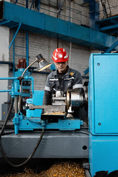 Senior man behind turning lathe