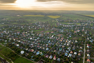 Aerial landscape of small town or village with rows of residential homes and green trees.