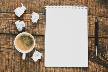 Blank notepad and coffee cup on office wooden table