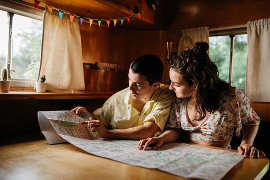 Couple reading map in camper